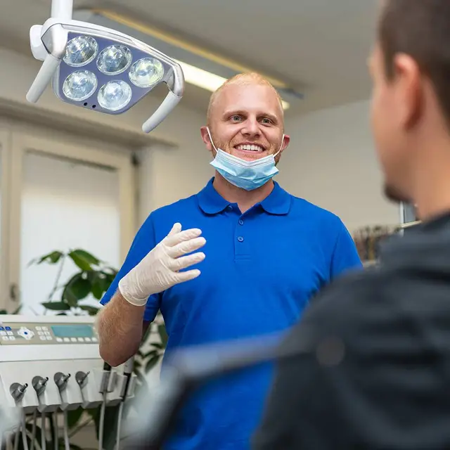 Zahnarzt im Gespräch mit einem Patienten